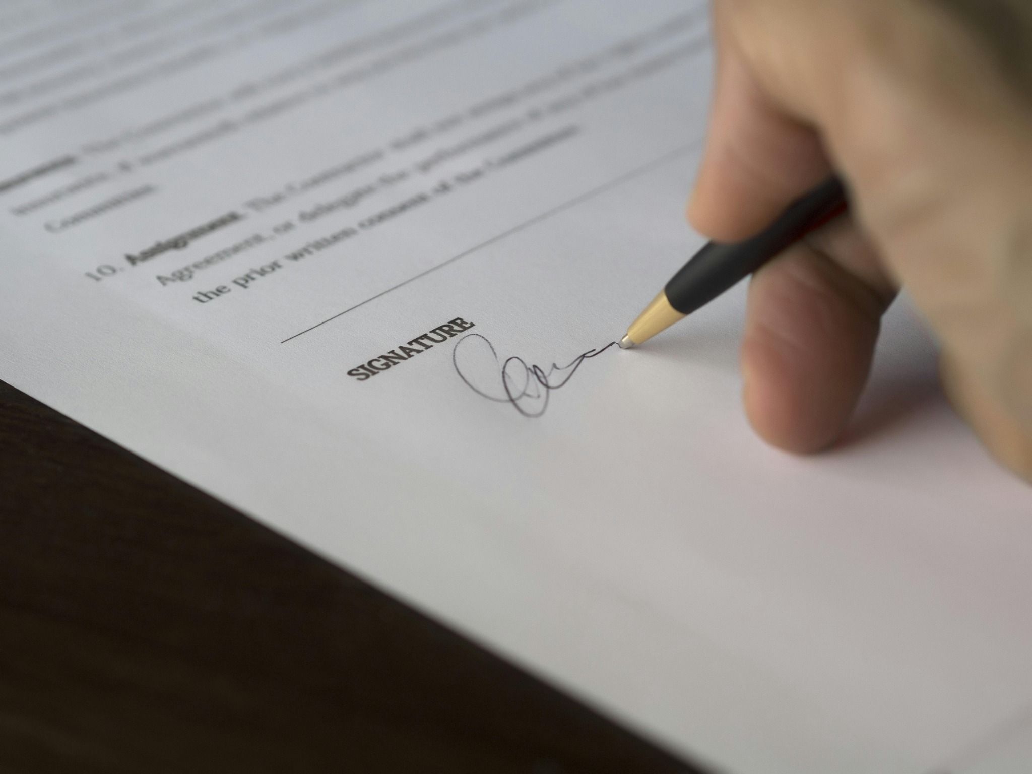 Ein Vertrag, der unterschrieben wird und ein Level Agreement symbolisiert