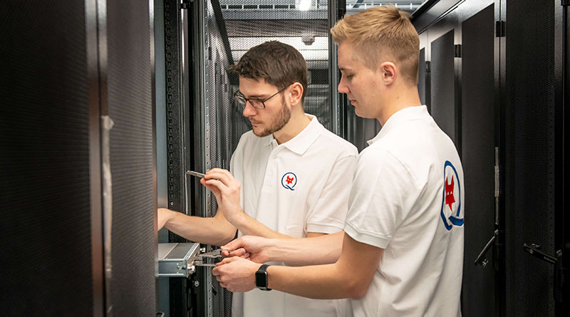 Colocation Rechenzentrum Zwei Mitarbeitende stehen vor Serverracks in einem Rechenzentrum